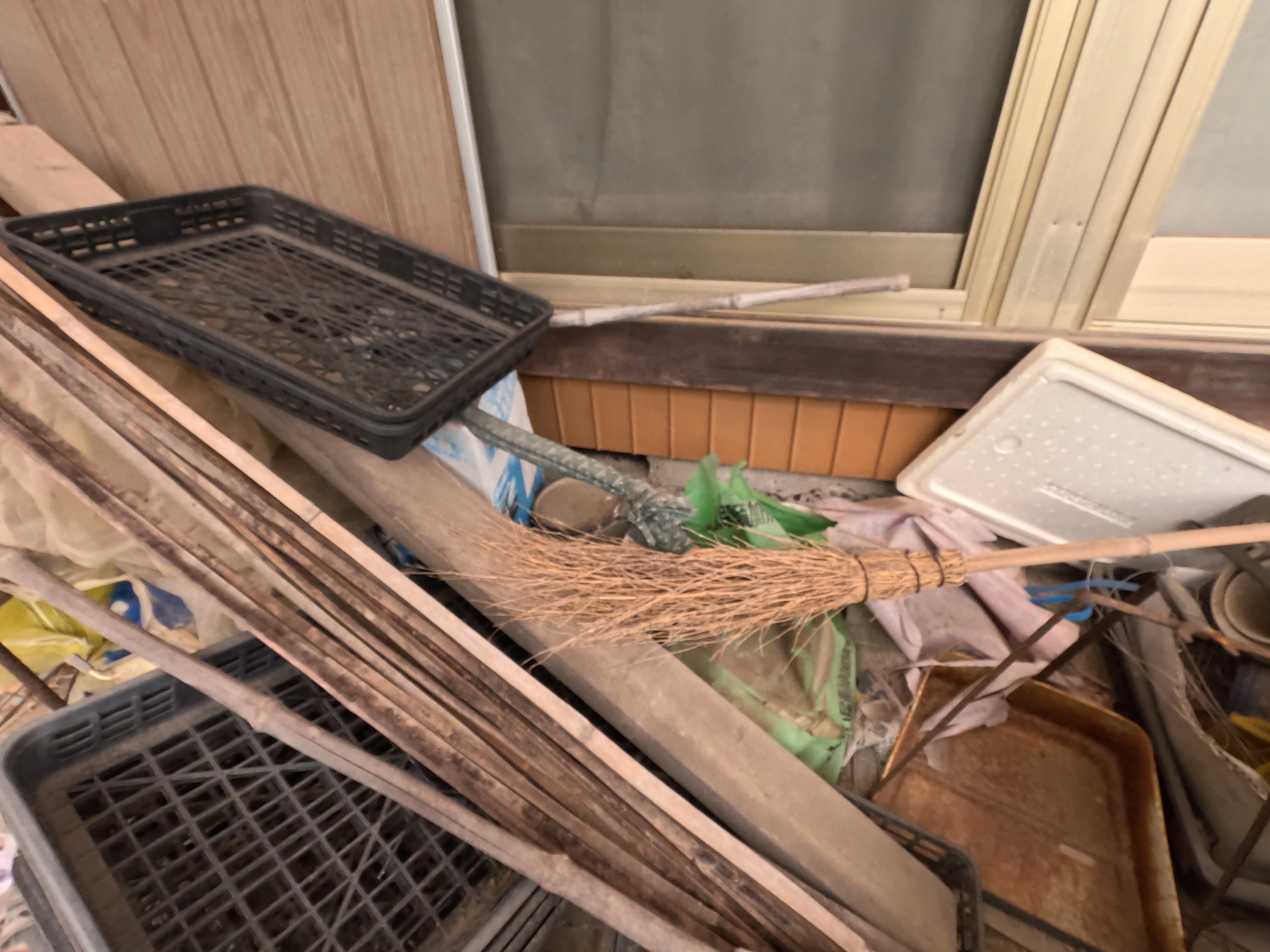 建物に密着するように放置された廃材