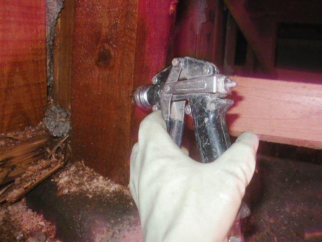 シロアリ駆除のため木材の内部に木部処理剤を注入する作業の様子